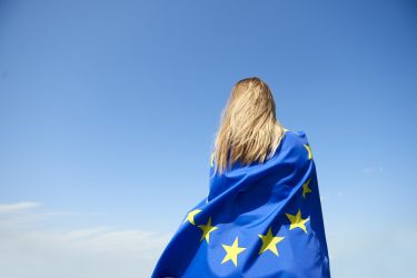 Rear view of young woman covered with European Union Flag